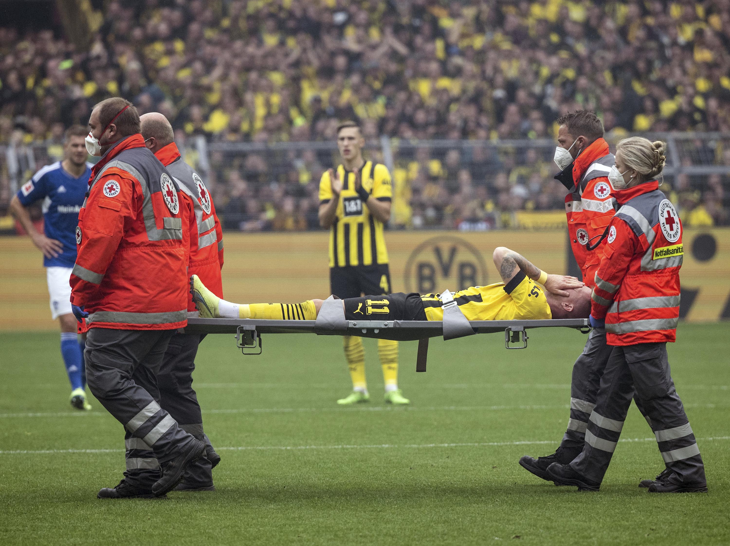 Врачи уносят футболиста Марко Ройса с поля после очередной травмы