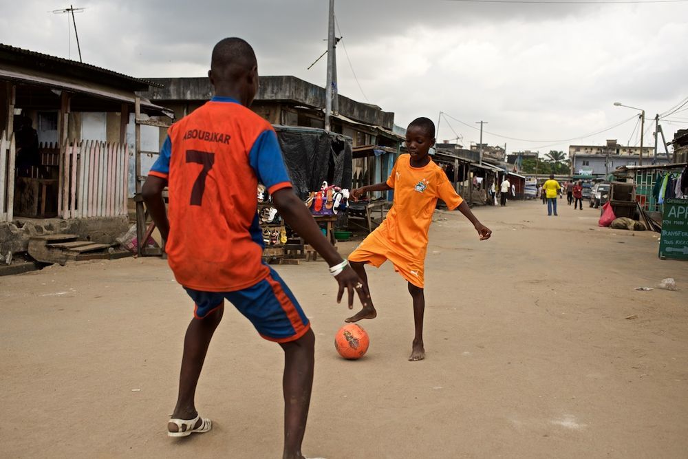 Дети играют в футбол на улице в Абиджане